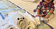 Raeyaa Jhade is registered to the contest to win money with this photo: toddler, child, baby, bed, towel_art, plush, indoor, curtains, pillow, blanket, dress, hair_clip, wristband, smiling, furniture, person, portrait, room, decor, cute