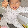 baby, child, smiling, pajamas, toy, peppa_pig, mickey_mouse, playpen, mesh, indoor, happy, cute, infant, sitting, reaching, colorful, plush_toy, floor, childrens_toy, young_child