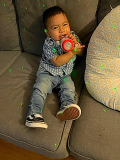 Aaron is registered to the contest to win money with this photo: baby, baby_toddler_clothing, baby_toys, child, comfort, face, fun, happy, head, leisure, person, play, recreation, room, sitting, skateboard, skateboarder, sleeve, toddler, toy