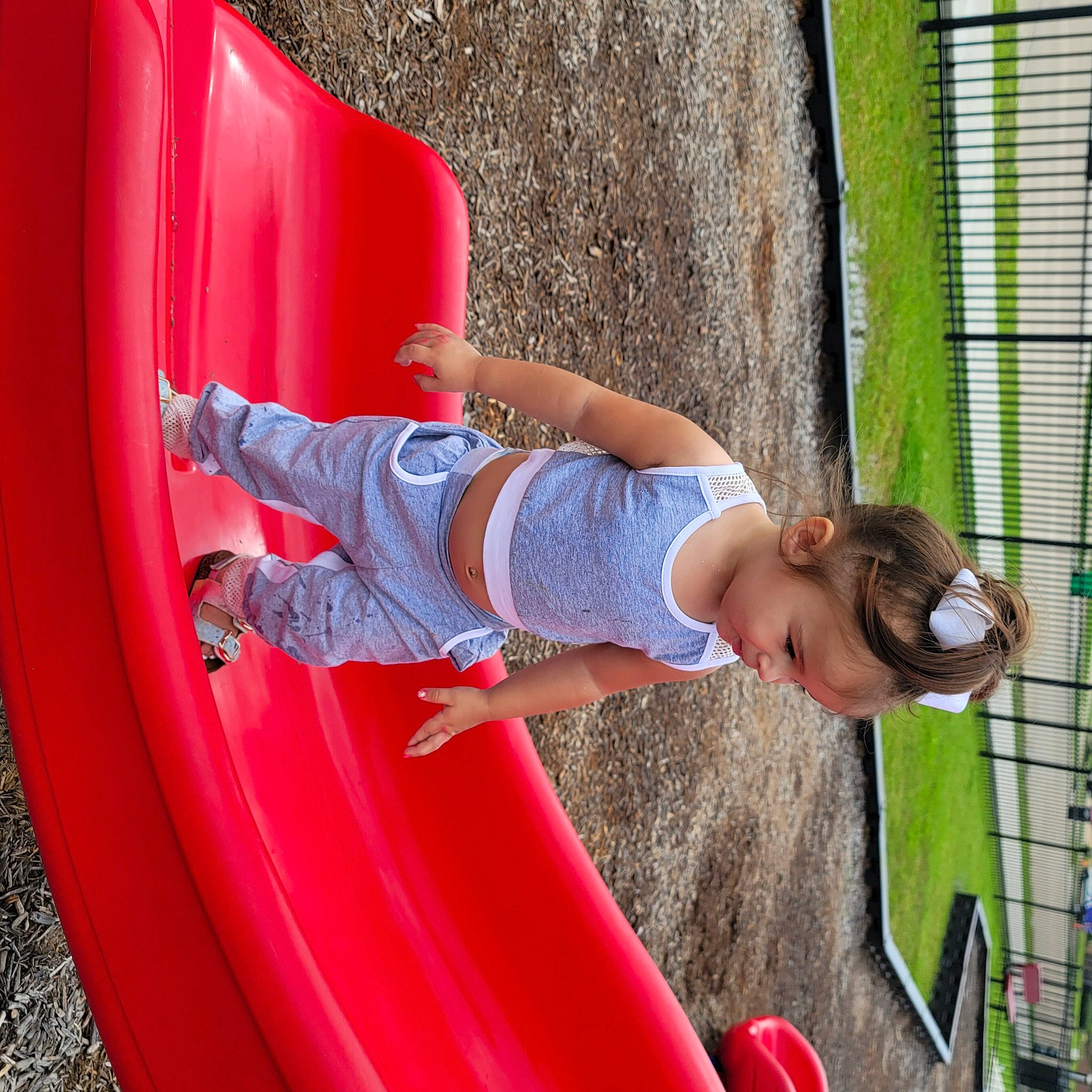 Justice is registered to the contest to win money with this photo: automotive_tire, baby_toddler_clothing, child, chute, city, clothing, fun, grass, leisure, magenta, mammal, outdoor_play_equipment, person, playground, playground_slide, recreation, red, t_shirt, tire, toddler