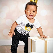 Kyrie joined the competition — help win amazing prizes! toddler, child, smiling, crown, birthday, gift_box, white_box, black_pants, white_shirt, indoor, floor, happy, standing, celebration, party, one_year_old, cute, posing, boy, photography