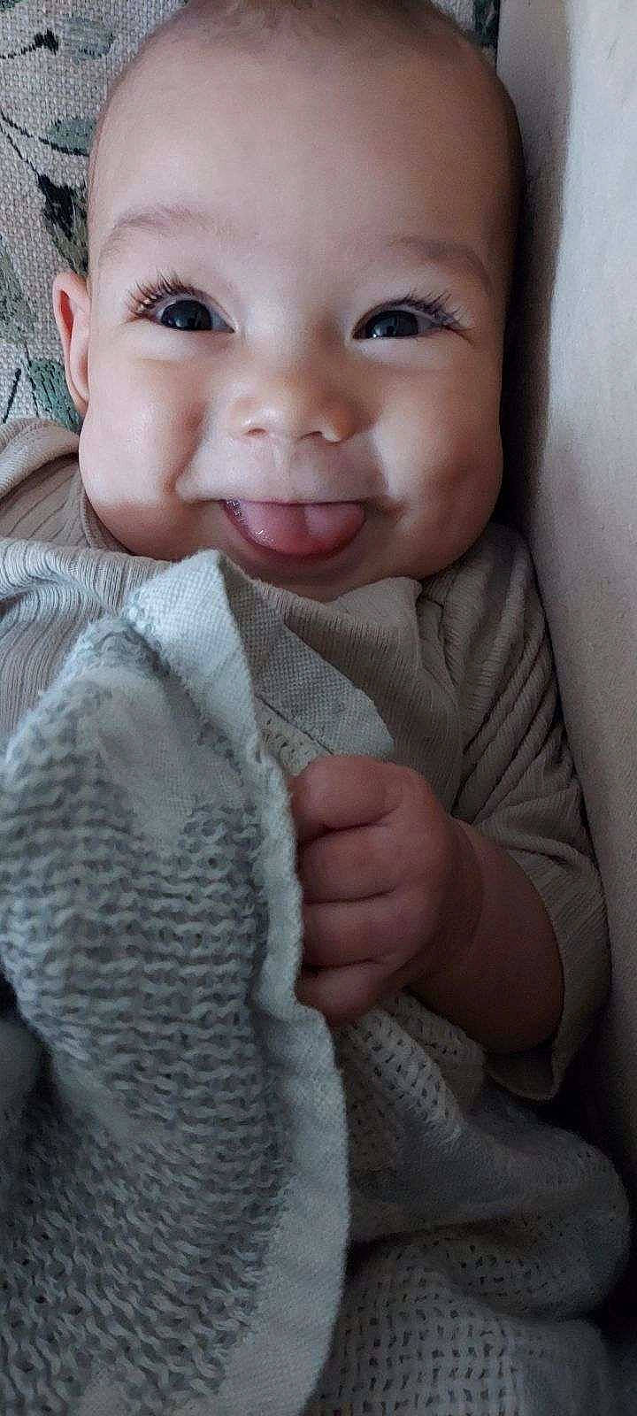 Oaklyn joined the competition — help win amazing prizes! baby, babylaughing, blanket, bodypart, clothing, face, finger, furniture, hand, happy, head, homedecor, laughing, mouth, pants, person, photography, portrait, quilt, smile