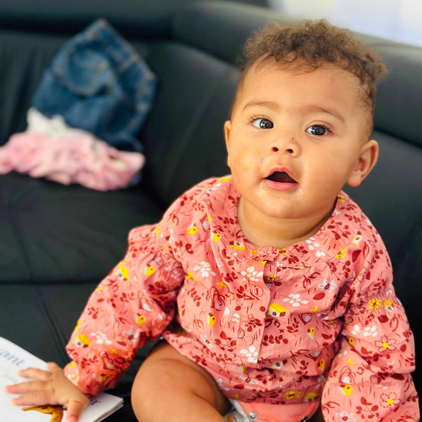 Jade participe au concours pour gagner de l'argent avec cette photo : baby, book, bright_eyes, casual, child, clothing, couch, curly_hair, cute, expression, face, furniture, hand, indoor, messy_face, person, pink_top, sitting, skin, socks