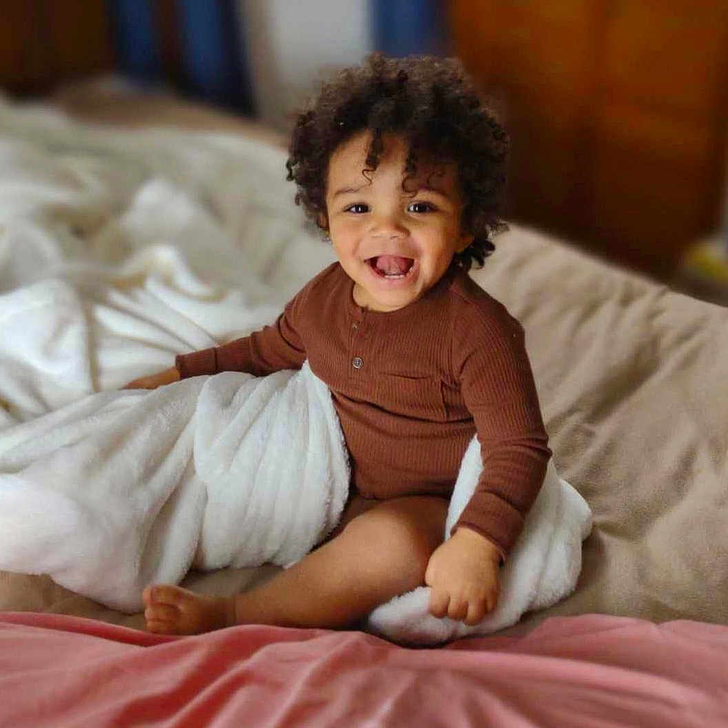 Leon is registered to the contest to win money with this photo: child, comfort, dress, eye, flash_photography, flooring, fun, happy, human_body, human_leg, leg, linens, mammal, room, sitting, skin, sleeve, smile, toddler, wood