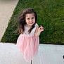 Snezhana is registered to the contest to win money with this photo: casual, child, cute, daylight, feet, flower, girl, grass, happy, holding, long_hair, nature, outdoor, person, pink_dress, portrait, sidewalk, small_flower, smile, young