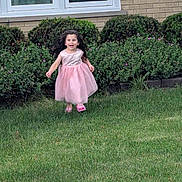 Snezhana joined the competition — help win amazing prizes! brick_wall, bushes, casual, child, curly_hair, daylight, flowering_plants, front_yard, girl, grass, happy, lawn, nature, outdoor, person, pink_dress, playful, running, smiling, window