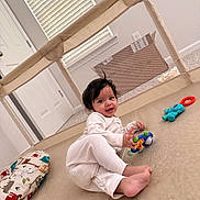 Arjun Panhasak joined the competition — help win amazing prizes! baby, child, indoor, playpen, toy, pajamas, floor, cushion, window, smile, face, person, home, carpet, door, light, colorful, cute, happy, infant