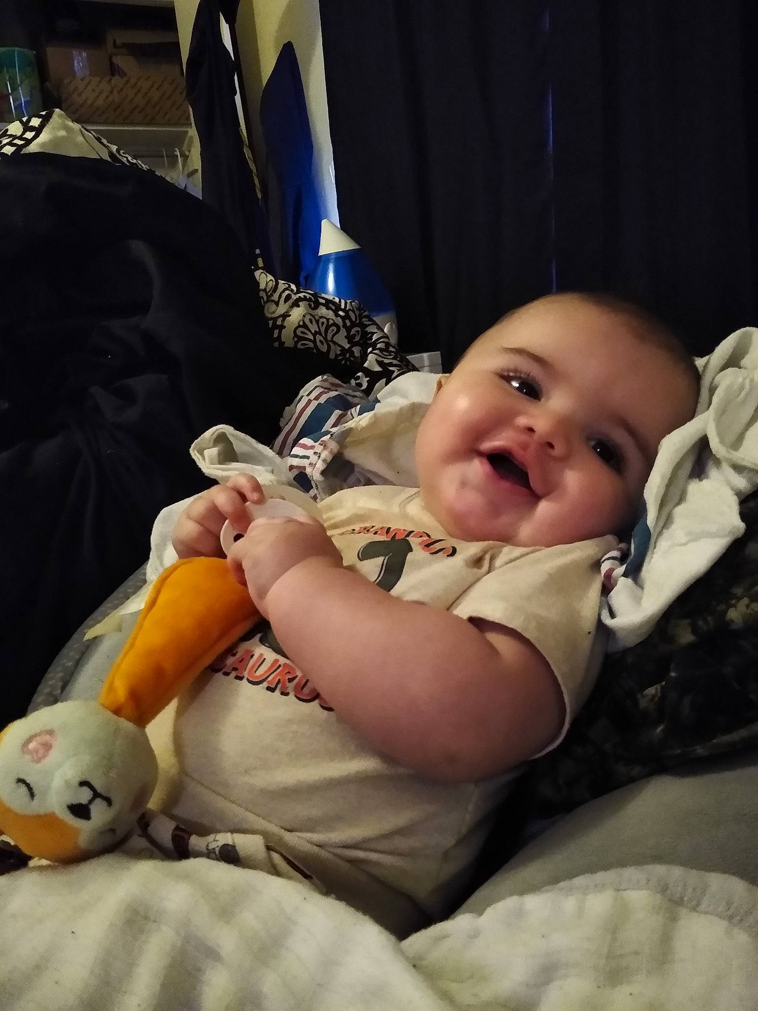 Lee is registered to the contest to win money with this photo: baby, baby_products, baby_toddler_clothing, car_seat, cheek, child, comfort, curtain, flash_photography, fun, happy, lap, person, portrait_photography, room, sitting, skin, smile, toddler, toy