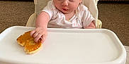Phoebe-Lin joined the competition — help win amazing prizes! baby, high_chair, pancake, food, hand, face, infant, couch, carpet, foot, clothing, person, indoor, table, expression, cute, sitting, skin, child, meal