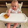 baby, high_chair, pancake, food, hand, face, infant, couch, carpet, foot, clothing, person, indoor, table, expression, cute, sitting, skin, child, meal