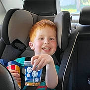 Graysen joined the competition — help win amazing prizes! child, car_seat, red_hair, smiling, cup, snack, car_interior, seatbelt, happy, young, person, window, daylight, casual_clothing, safety, kid, portrait, vehicle, travel, fun