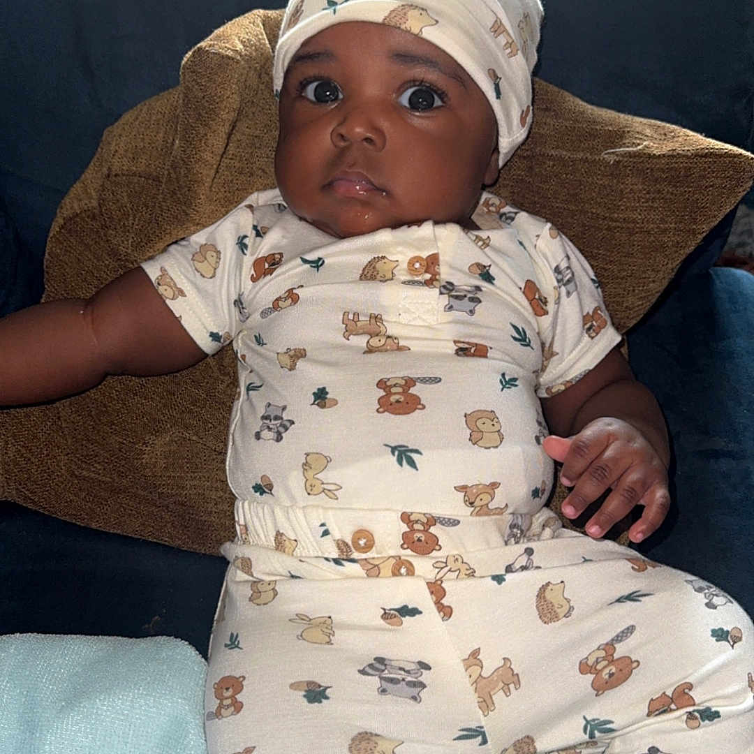 Zailyn joined the competition — help win amazing prizes! animal_print, baby, blanket, child, couch, cozy, cute, face, furniture, hand, hat, indoors, infant, looking_up, onesie, pillow, portrait, relaxed, sleepwear, soft_toys