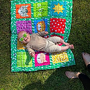 Heath joined the competition — help win amazing prizes! baby, sunglasses, quilt, grass, outdoor, sunlight, baby_clothing, colorful, patchwork, feet, barefoot, smile, infant, cheerful, relaxing, summer, blanket, person, toy, nature