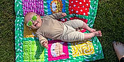 Heath joined the competition — help win amazing prizes! baby, baby_clothing, barefoot, blanket, cheerful, colorful, feet, grass, infant, nature, outdoor, patchwork, person, quilt, relaxing, smile, summer, sunglasses, sunlight, toy