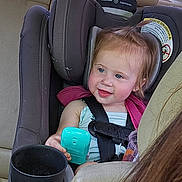 Raylenn joined the competition — help win amazing prizes! toddler, car_seat, child, toy, blue, car_interior, seatbelt, smiling, hair, pony_tail, window, daylight, backseat, human, person, clothing, seat, safety, happy, automobile