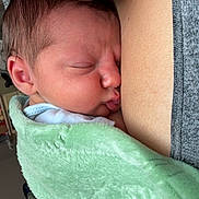 Arlo joined the competition — help win amazing prizes! newborn, baby, infant, sleeping, peaceful, face, portrait, caregiver, parent, cuddling, blanket, green_blanket, swaddled, close_up, indoors, cozy, resting, eyes_closed, skin_to_skin, family