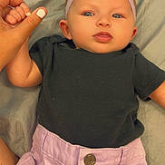 Ryleigh is registered to the contest to win money with this photo: baby, black_shirt, blanket, blue_eyes, child, clothing, cute, face, hand, headband, holding, human, indoor, infant, lying_down, portrait, purple_shorts, skin, thumb, toddler