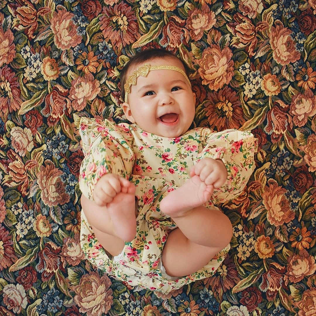 Xiomara is registered to the contest to win money with this photo: baby, cheek, child, hand, happy, leaf, pattern, person, photography, plant, sitting, skin, smile, toddler, tree