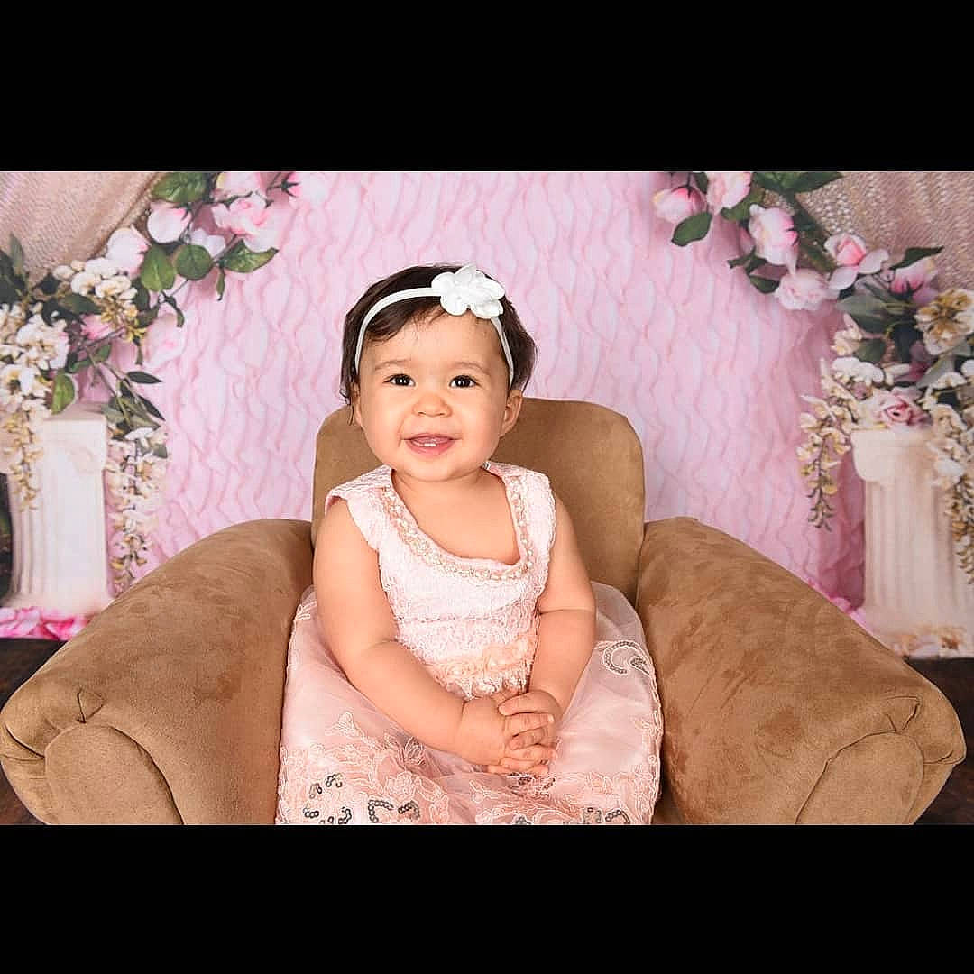 Xiomara joined the competition — help win amazing prizes! baby, beauty, child, dress, ear, gown, hair_accessory, happy, head, headgear, headpiece, human, joy, lace, outerwear, person, pink, sitting, skin, smile