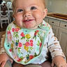 baby, child, smiling, bib, high_chair, indoor, kitchen, face, person, cute, happy, clothing, furniture, table, seat, pink, skin, head, eyes, hands