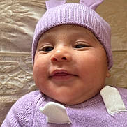 Dylan Andrés joined the competition — help win amazing prizes! baby, infant, face, smile, hat, knitwear, purple, clothing, cute, child, portrait, closeup, cheeks, lying_down, soft_texture, blanket, warm, cozy, indoors, happy