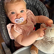 Leonie a rejoint le concours — aidez-le/la à gagner de superbes lots ! baby, child, pacifier, stuffed_animal, high_chair, pink_bow, blonde_hair, blue_eyes, soft_lighting, cute, indoor, clothing, plush_toy, infant, portrait, closeup, hand, face, sitting, adorable