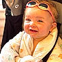 baby, child, smiling, blanket, sunglasses, happy, stroller, clothing, face, headwear, infant, cute, portrait, toddler, seatbelt, indoor, skin, hand, foot, cheerful