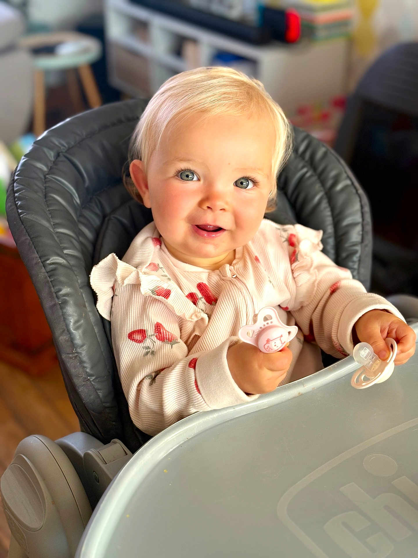 Leonie a rejoint le concours — aidez-le/la à gagner de superbes lots ! toddler, child, high_chair, pacifier, smile, blond_hair, blue_eyes, baby_clothes, indoor, furniture, table, cute, happy, infant, person, portrait, young_child, home, seated, feeding_chair