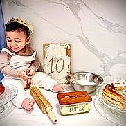 Sohan a rejoint le concours — aidez-le/la à gagner de superbes lots ! child, toddler, crown, rolling_pin, pastries, butter, baking, sign, table, smile, happy, kitchen, plate, flour, bowl, cooking, celebration, food, sitting, portrait