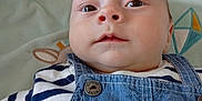 Marius participe au concours pour gagner de l'argent avec cette photo : animal_illustration, baby, button, child, closeup, clothing, colorful, cute, denim_overalls, eyes, fabric, face, infant, lying_down, owl, patch, patterned_background, portrait, skin, striped_shirt