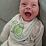 apparel, avocado, baby, bib, closeup, clothing, comfort, couch, cute, expression, face, happy, indoors, infant, joyful, person, relaxing, sitting, smiling, young_child