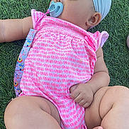 Alani joined the competition — help win amazing prizes! baby, infant, child, pacifier, headband, pink_clothing, elephant_pattern, grass, outdoor, legs, feet, hand, cute, chubby, skin, person, lying_down, summer, daylight, nature