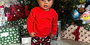 Patience joined the competition — help win amazing prizes! child, toddler, christmas_tree, presents, holiday, red_sweater, patterned_pants, shoes, floor_tiles, indoor, decorations, gift_wrap, bow, holiday_lights, festive, cute, smiling, celebration, home, portrait