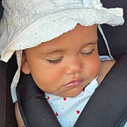 Manël participe au concours pour gagner de l'argent avec cette photo : baby, sleeping, hat, white_hat, car_seat, harness, red_button, child, face, closed_eyes, cute, infant, clothing, safety, resting, adorable, portrait, seatbelt, summer_hat, peaceful