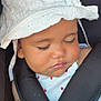 baby, sleeping, hat, white_hat, car_seat, harness, red_button, child, face, closed_eyes, cute, infant, clothing, safety, resting, adorable, portrait, seatbelt, summer_hat, peaceful