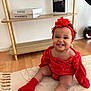 Manël a rejoint le concours — aidez-le/la à gagner de superbes lots ! baby, smiling, red_clothing, headband, sitting, rug, indoor, wooden_floor, books, shelf, magazine, happy, child, person, cute, cozy, home, furniture, decor, floor