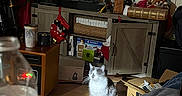 Bella joined the competition — help win amazing prizes! cat, indoor, wooden_floor, television, stocking, box, water_bottle, cabinet, holiday_decor, furniture, living_room, light_spot, blurred_foreground, pet, cozy, clutter, plastic_bottle, electronics, curtains, decorations
