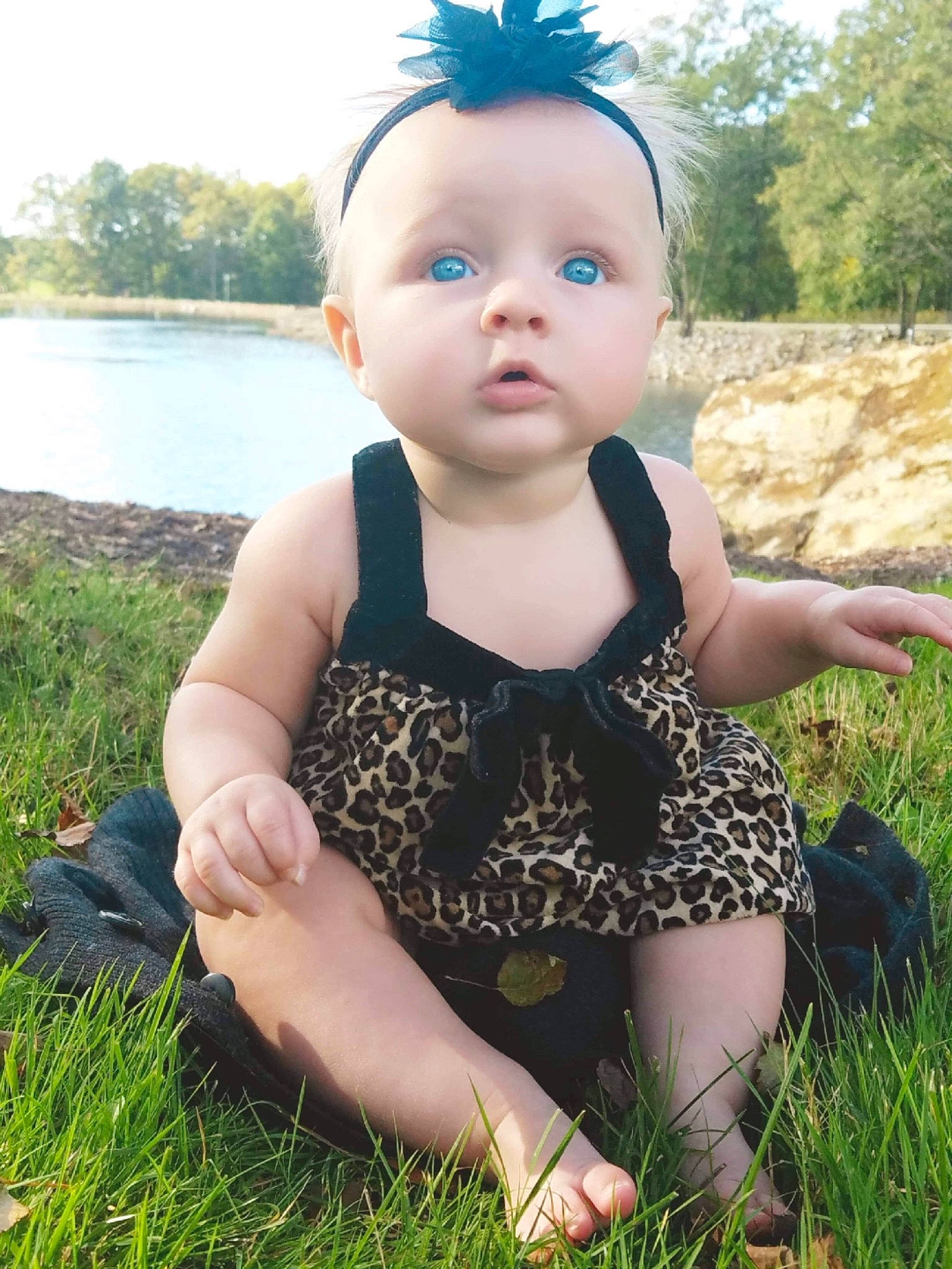 Makayla is registered to the contest to win money with this photo: baby, baby_toddler_clothing, child, dress, face, fawn, grass, grass_family, head, meadow, pattern, person, plant, sitting, skin, smile, summer, toddler