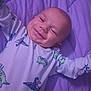 Joey joined the competition — help win amazing prizes! baby, smiling, dinosaur_pattern, onesie, purple_quilt, infant, happy, lying_down, child, cute, portrait, face, arms_outstretched, sleepwear, indoors, young_child, head, skin, cheerful, cozy