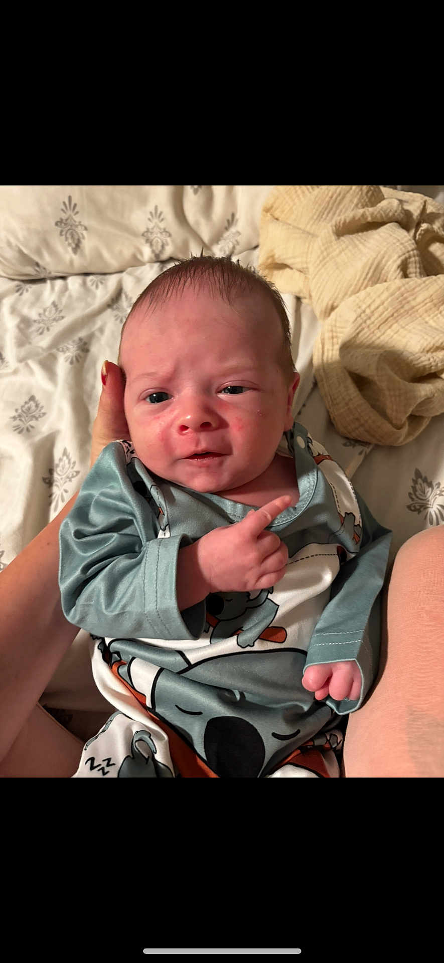 Jace joined the competition — help win amazing prizes! baby, infant, hand, clothing, bed, blanket, person, face, expression, sleepwear, newborn, skin, human, cute, lying_down, comfort, indoor, young_child, holding, gesture