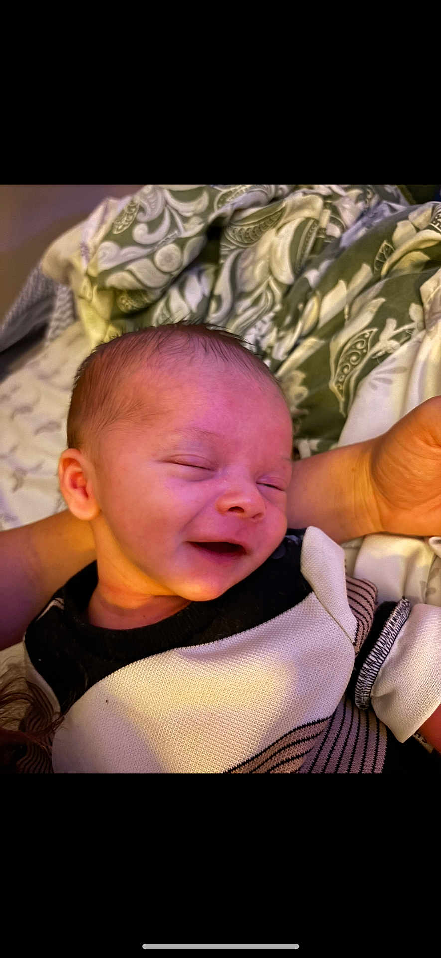 Jace is registered to the contest to win money with this photo: baby, infant, sleeping, smiling, person, face, arm, clothing, blanket, pattern, fabric, comfort, cozy, closeup, skin, head, newborn, rest, soft, indoors