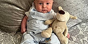 Luca joined the competition — help win amazing prizes! baby, barefoot, bed, child, clothing, comfort, cozy, cute, expression, face, indoors, infant, overalls, patterned_bedspread, pillow, plush, portrait, sitting, soft_toy, stuffed_toy