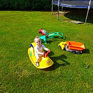 Melvyn a rejoint le concours — aidez-le/la à gagner de superbes lots ! casual_clothing, child, fun, garden, grass, greenery, happy, lawn, outdoor, play, playtime, smile, snail_rocker, summer, sunlight, toddler, toy, toy_truck, trampoline, yellow