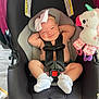 baby, car_seat, smiling, bow, infant, toy, unicorn, plush, socks, straps, seatbelt, cute, child, indoor, car_seat_warning, pink, black, gray, comfort, happy