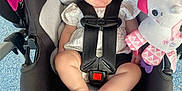 Laylah is registered to the contest to win money with this photo: baby, car_seat, blue_bow, smiling, unicorn_toy, infant, child, safety_harness, black_car_seat, happy, cute, indoors, plush_toy, footwearless, white_clothing, headband, toy, floor, person, seat