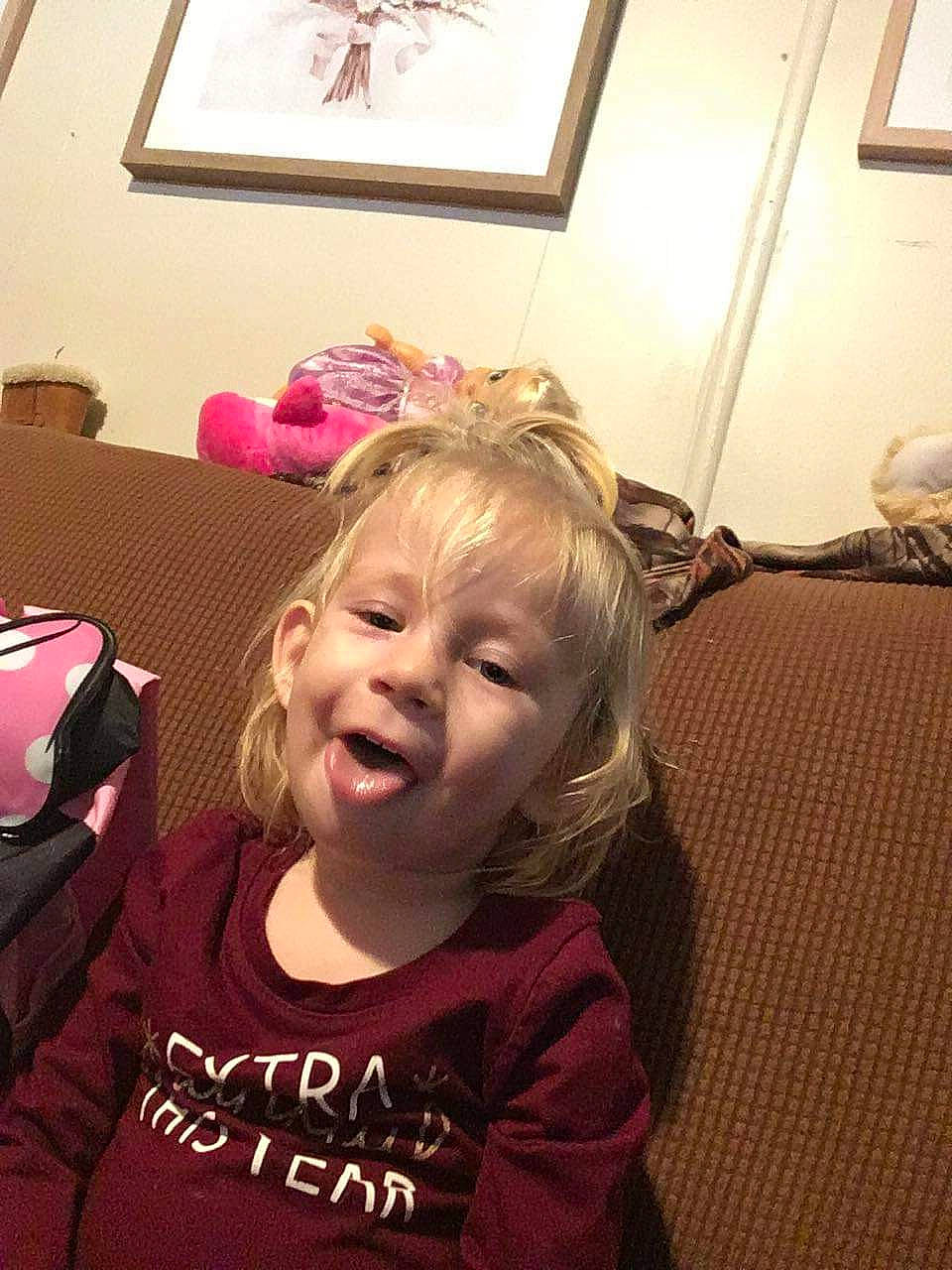 Alaiya joined the competition — help win amazing prizes! bangs, brown_hair, cheek, child, comfort, flooring, fun, happy, head, laugh, luggage_and_bags, mouth, person, picture_frame, room, sitting, sleeve, smile, t_shirt, toddler