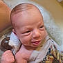 baby, infant, newborn, bathtub, bubbles, towel, foam, water, bath_time, face, head, hand, smile, tongue, skin, closeup, cloth_pattern, sunflower_pattern, happy, relaxed