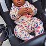 baby, child, floral_outfit, headband, stroller, infant, cute, indoors, portrait, sitting, clothing, expression, hands, face, person, young_child, floor, footwear, pink, black