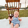 baby, denim_overalls, wooden_chair, blanket, outdoor, grass, smiling, blue_eyes, infant, nature, relaxing, daylight, cute, child, portrait, summer, peaceful, playing, sitting, happy