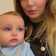 Sian Nakoleci a rejoint le concours — aidez-le/la à gagner de superbes lots ! baby, child, woman, portrait, face, person, indoor, clothing, casual, blonde_hair, blue_eyes, looking_away, closeup, young_adult, soft_lighting, family, mother_and_child, expression, skin, head_and_shoulders